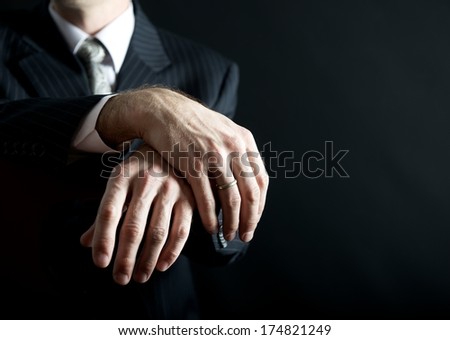Man in suit hands fragment photo, hands close up isolated on black, groom hands fragment, grooms hands with wedding ring, mans hands with ring fragment photo in uneven light, artist