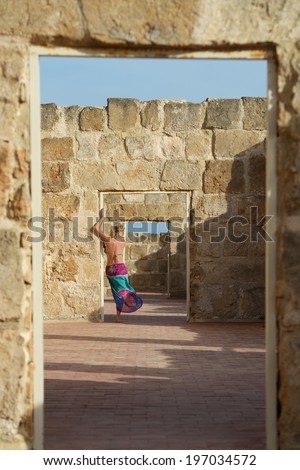 Young woman figure standing in old factory between doors.Young woman on windy day standing in old factory ruins. Woman figure. Unknown. Holidays mood. Sicily. Old factory in Vendicari, Sicily, Italy
