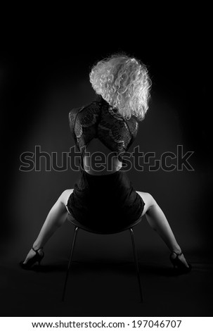 Young woman in black elegant dress back fragment photo, fashion photo close up, young woman isolated on black, artistic photo, female model isolated in dark background, female fashion photo, concept