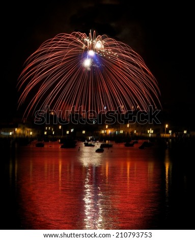 Colorful fireworks explosion with marvellous reflection on the sea, 4 of July, Independence day, explode, fireworks with village silhouette in background in Birzebugga, Malta.Malta fireworks festival