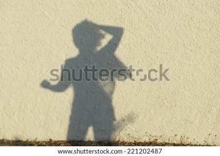 Silhouette of woman figure on natural wall background.Women figure on a wall, artistic photo. Contrast, silhouette of woman figure on sunny day