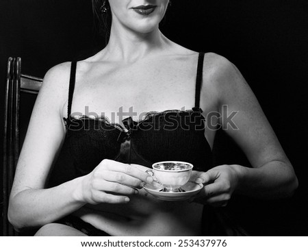 Woman drinking coffee in black and white photo, erotic woman body and hand fragment with cup of coffee, conceptual photo, woman body, body part, woman in underwear, fashionable lady, black underwear
