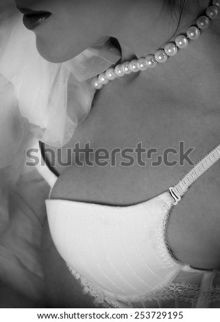 Pearl necklace and woman breast close up, black and white photo, woman breast fragment with pearl neclace, conceptual photo, jewelry, woman body fragment, body, jewelry fashion background, fashionable