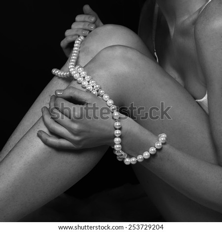 Pearl necklace in woman hands in black and white photo, woman hand fragment with pearl necklace, conceptual photo, jewelry, woman body fragment, body part, jewelry fashion background, fashionable