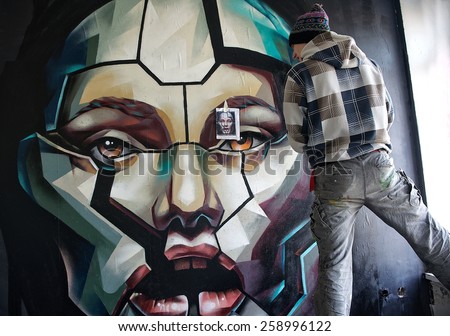 VILNIUS, LITHUANIA - MARCH 8: street artist painting on a wall in old building on Mar 8, 2015 in Vilnius, Lithuania. Young artist participate in social event in Vilnius, Lithuania