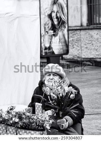 VILNIUS, LITHUANIA - MARCH 7: woman selling flowers in annual traditional crafts fair - Kaziuko fair on Mar 7, 2015 in Vilnius, Lithuania. Woman selling flowers in the street. Black and white photo