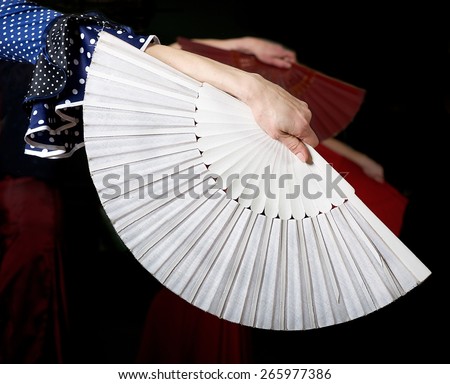White fan and fragment of woman hand in flamenco performance, fragment photo of flamenco dancer, spanish fan, flamenco