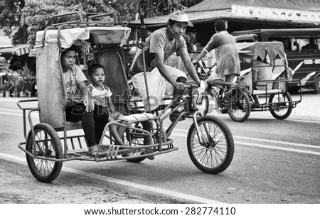 BOHOL, PHILIPPINES - FEB 3: traditional and typical transport in the street of Bohol, Philippines,Feb 3, 2014. Tricycle motor taxi, Philippines inexpensive transport service. Black and white photo