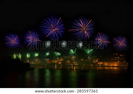 Fireworks. Fireworks explosion in dark sky with city sillouthe and colorful reflect on water in Valletta, Malta. Violet fireworks. Malta fireworks festival, 2015, 4 of July,New Year, maltese fireworks