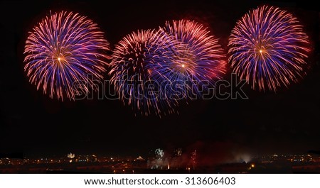 Fireworks. Colorful violet fireworks in Malta, dark sky background and house light in the far, Malta fireworks festival, 4 of July, Independence day, New Year, maltese fireworks.Zurrieq, Malta