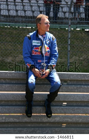 red bull race car driver sitting on guard rail, Nuerburgring race track, Germany