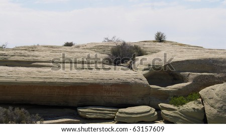 A rock formation with graffiti in the desert.