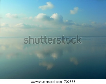 Winter ice on sea and surreal reflection. The sky vaulted over the sea