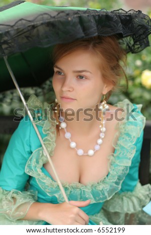 High society girl with umbrella and amazing neckless in fancy dress