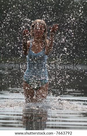 Girl plays with water and splashing small drops