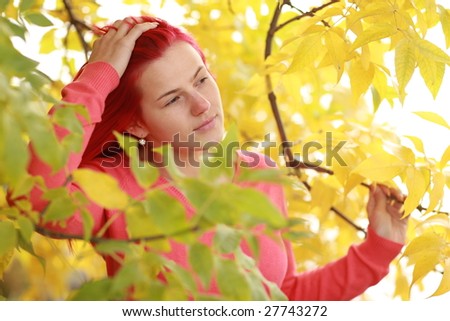 Nice autumn portrait with red haired girl and yealow leafs