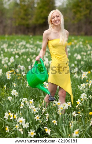 Beautiful blond girl works in narcissus field