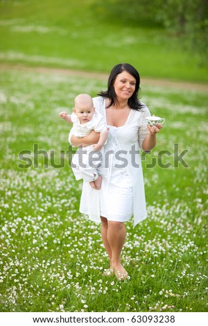 Mother with small child in flower field, nice summer day