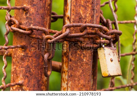 The old Old rusty gate lock on a old iron door.