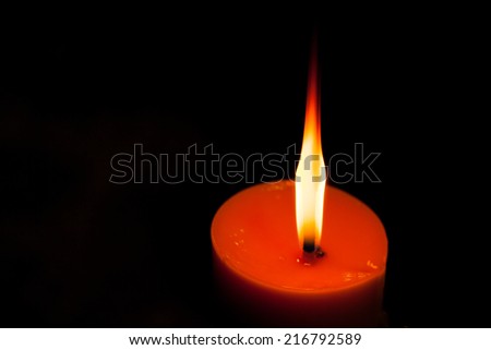 A burning candle in dark.