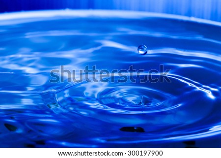 Blue water drop falling down background.