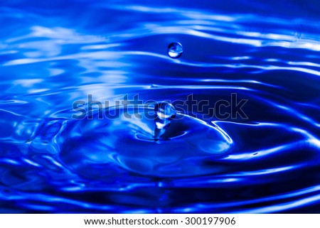 Blue water drop falling down background.
