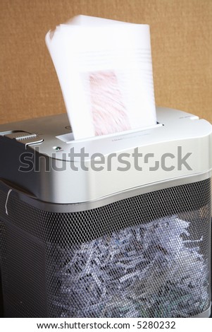 A paper shredder at work.  Some motion blur of the paper being pulled into the machine.