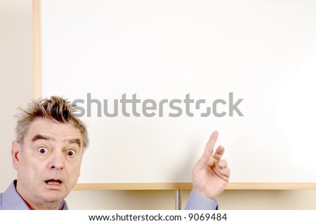 Wide-eyed man presenting at a whiteboard