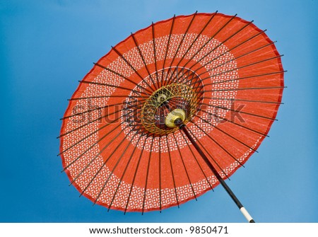 stock-photo-a-colorful-oriental-umbrella-red-on-a-blue-background-9850471.jpg