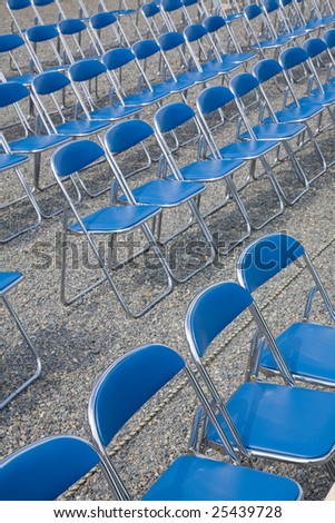 Empty folding chairs arranged for an event.
