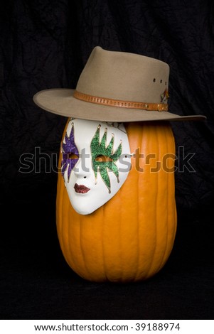A pumpkin wearing a hat and a mask.