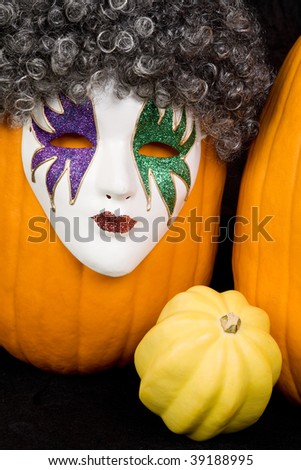 A pumpkin wearing a mask and wig, and friends.