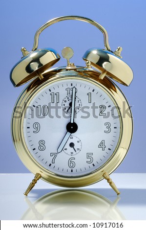 Old fashioned alarm clock on a blue background.