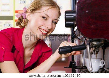 Friendly waitress making coffee at coffee machine