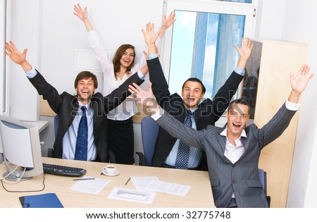 Joyful business team in office celebrating in office