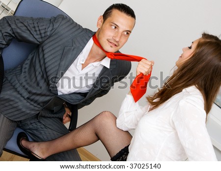 Young businessman and businesswoman flirting in office