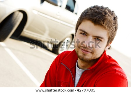 Friendly young handsome man with his car
