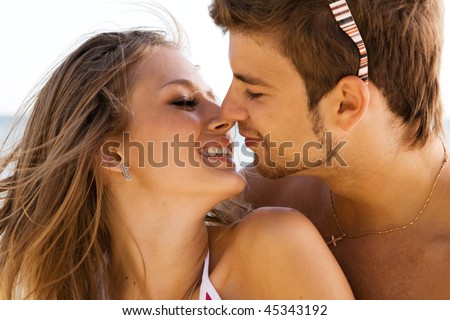 stock photo Young beautiful couple kissing at the sea shore