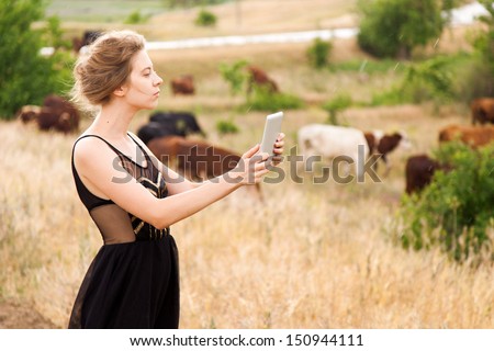 Young woman with a tablet pc in a countryside