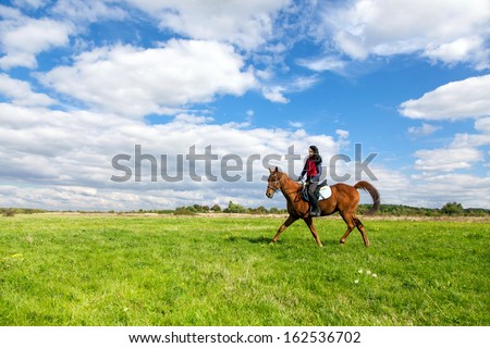 Young woman riding a horse in the countryside