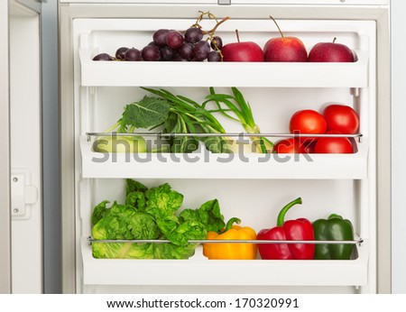 Open refrigerator full of fresh fruit and vegetables