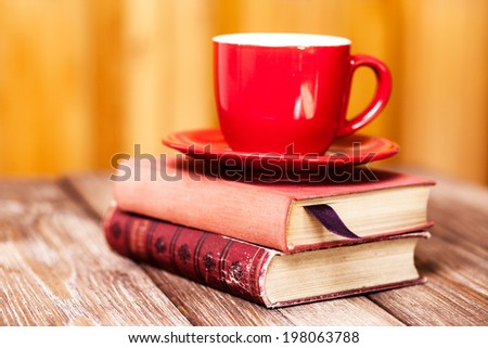 Books and a coffee cup on a wooden table