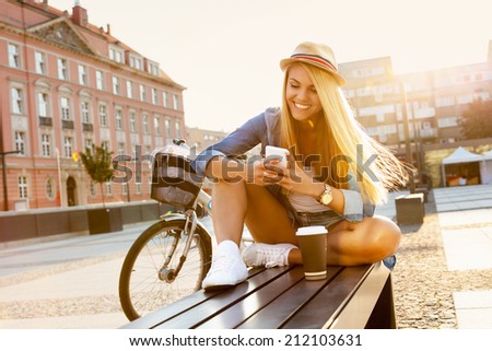 Young stylish woman with a bicycle in a city street