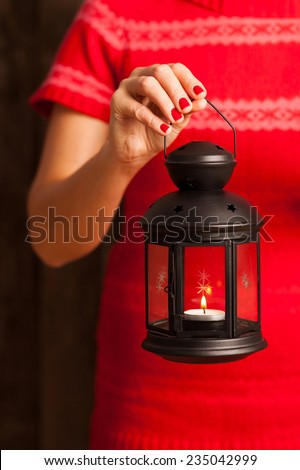 Female hands holding a lantern