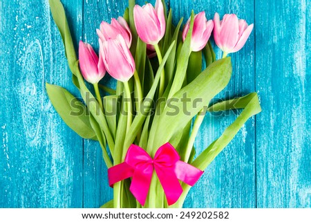 Beautiful pink tulips on blue wood background.