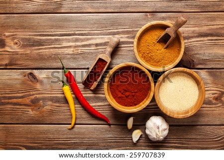 Bowls with spices on wooden table