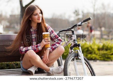 Young woman drinking coffee on a bicycle trip.