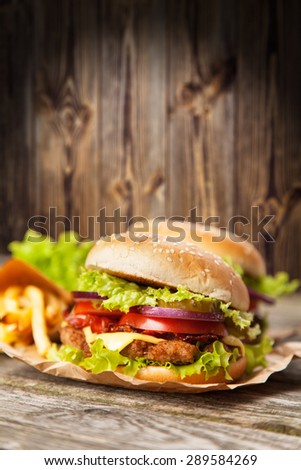 Delicious hamburger and french fries on wooden background