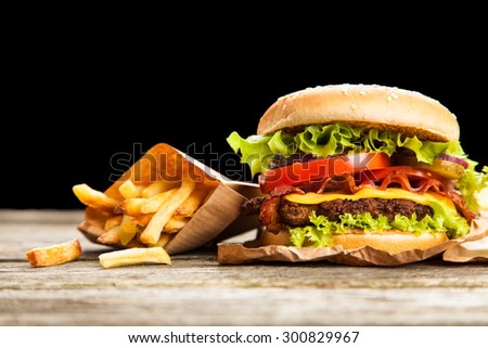 Delicious hamburger and french fries on wooden background