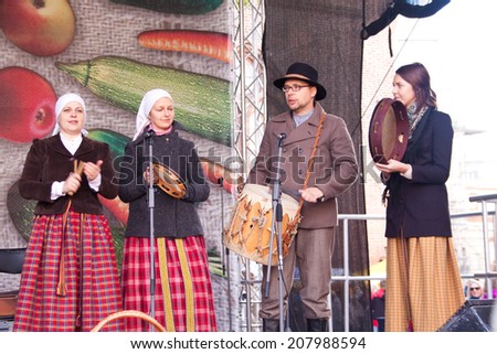 RIGA, LATVIA -  SEPTEMBER 28, 2013: People in national costumes perform traditional songs on the scene during the Latvian harvest holiday Mikeldienas.